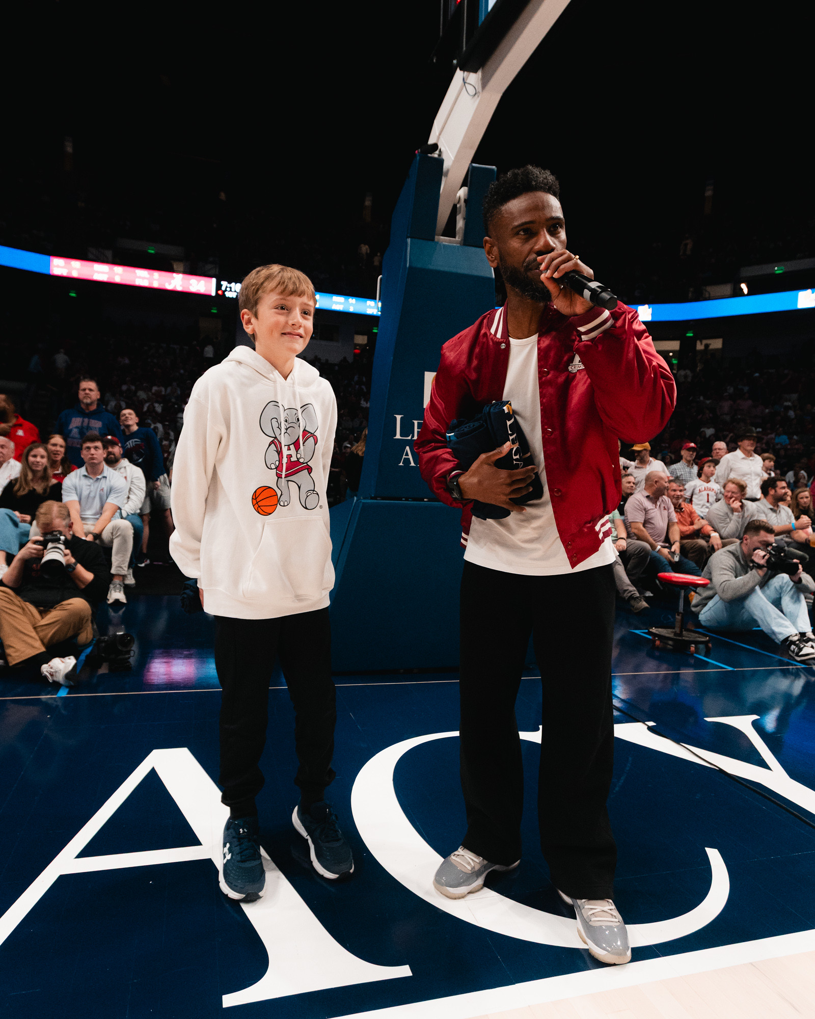 The in-arena host with a young fan on the court